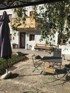 une terrasse avec une table, un parasol et un banc dans l'établissement Pferdehof Dietzsch,Tittmoning, à Tittmoning
