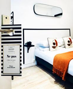 a bedroom with a bed with a no pas disorder sign at Hôtel Gaspard in Le Touquet-Paris-Plage