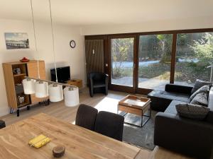 uma sala de estar com um sofá e uma mesa em Großzügiges Domizil, 90qm, mit Terrasse, Garten und Garage em Marquartstein