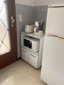 een keuken met een magnetron en een koelkast bij Chez Cathy et Alain in Saint-Laurent-dʼAigouze +2 foto's