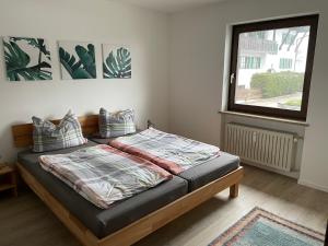 uma cama num quarto com uma janela e um visor de cama em Großzügiges Domizil, 90qm, mit Terrasse, Garten und Garage em Marquartstein