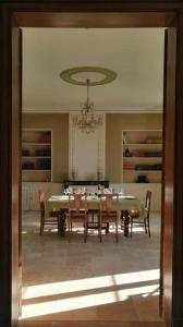 a dining room with a table and chairs and a chandelier at Les Croque-Notes, chambres et table d'hôtes in Lorignac