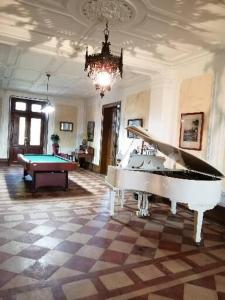 a room with a piano and a pool table at Les Croque-Notes, chambres et table d'hôtes in Lorignac