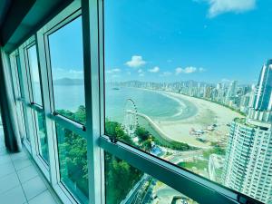 - une vue sur la plage depuis la fenêtre d'un bâtiment dans l'établissement Cobertura Melhor Vista do Mar Balneário Camboriú, à Balneário Camboriú