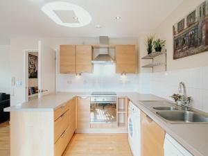 a kitchen with white cabinets and a sink at Jyde Apartments - Sheffield City Centre in Sheffield