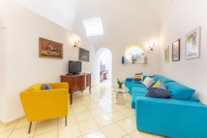 a living room with a blue couch and yellow chairs at Casa Palazzo Merlato in Procida
