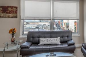 a living room with a leather couch and a window at Furnished 2 Bedroom Apartment near National Museum apts in Washington, D.C.