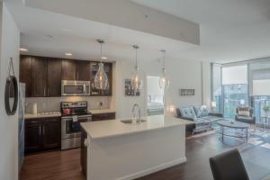 a kitchen with a white counter top and a living room at Atlanta Buckhead Fully Furnished Apartment apts in Atlanta
