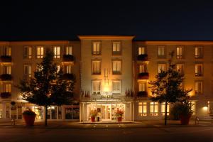 a large building with a store front at night at Hotel Garni Lindacher Hof in Burghausen