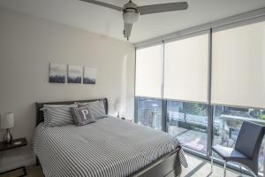 een slaapkamer met een bed, een stoel en een raam bij High Rise 2 Bedroom apartment in a Great location apts in Atlanta