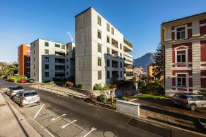 Blick auf eine Stadtstraße mit Gebäuden und Autos in der Unterkunft GuestHouse Lugano Center Apartments by LR in Lugano