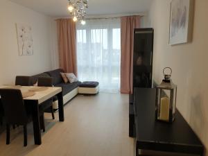 een woonkamer met een tafel en een bank en een eetkamer bij Caskada Modern Apartment 3 in Słupsk