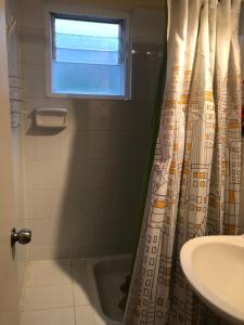 a bathroom with a shower curtain and a sink at Comoda y amplia casa en sector residencial in Coquimbo +25 photos