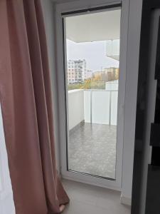 een glazen schuifdeur met uitzicht op een balkon bij Caskada Modern Apartment 3 in Słupsk