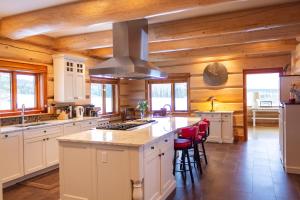 uma cozinha com armários brancos e um forno com placa de fogão em Jollymore Ranch em Smithers