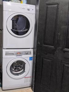 a washer and dryer sitting next to a door at Modern & Luxurious Suites in Surrey in Surrey