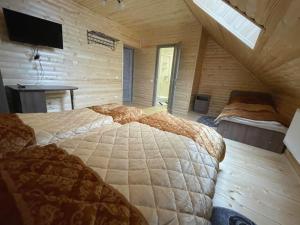 マイコリチンにあるApart-hotel ORLANの木造キャビン内のベッドルーム1室(大型ベッド1台付)