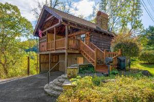 a log cabin with a staircase and a deck at Cozy Studio Log Cabin in the heart of Pigeon Forge. Hot Tub. Honeymoon! Sleeps 2 in Pigeon Forge