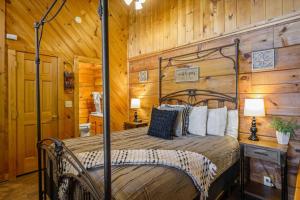 a bedroom with a bed in a room with wooden walls at Cozy Studio Log Cabin in the heart of Pigeon Forge. Hot Tub. Honeymoon! Sleeps 2 in Pigeon Forge