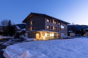 un gran edificio con nieve delante en LISAL Appartements en Altenmarkt im Pongau