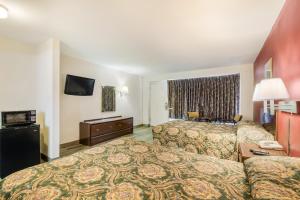 una camera d'albergo con due letti e una televisione di Knights Inn - Cleveland a Cleveland