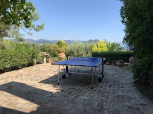 a ping pong table sitting on a brick patio at The Seacret Beachfront Villa in Néa Péramos