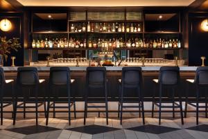a bar with chairs lined up behind a counter at Kimpton - Harper Hotel, an IHG Hotel in Fort Worth