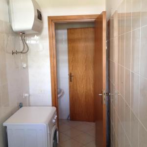 een badkamer met een toilet en een houten deur bij I Giardini e Le Terrazze in Mascali