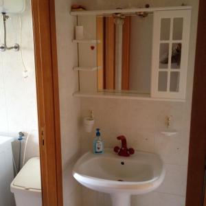 een badkamer met een wastafel, een spiegel en een toilet bij I Giardini e Le Terrazze in Mascali