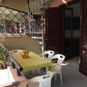 une table et des chaises sur un balcon avec un escalier en colimaçon dans l'établissement I Giardini e Le Terrazze, à Mascali