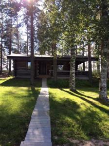 a log cabin in the middle of a yard with trees at Holiday Pyhäniemenranta in Kihniö