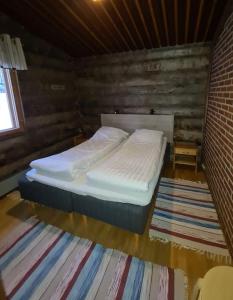 a bedroom with a bed in a wooden room at Holiday Pyhäniemenranta in Kihniö