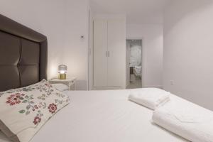biała sypialnia z dużym łóżkiem z poduszką w obiekcie WintowinRentals Malaga Center, Comfortable and Renovated w Maladze