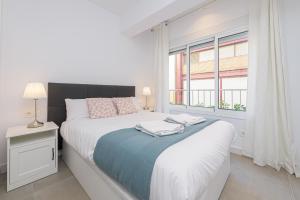 biała sypialnia z łóżkiem i oknem w obiekcie WintowinRentals Malaga Center, Comfortable and Renovated w Maladze