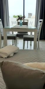 羅薩里奧的住宿－Suites Quality 2 - Rosario，餐桌、椅子、桌子和床