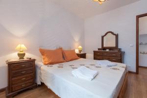 ein Schlafzimmer mit einem Bett mit zwei Kommoden und einem Spiegel in der Unterkunft Casa do Outeiro in Mondim de Basto + 44 Fotos