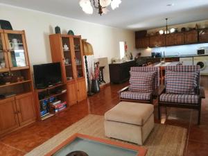ein Wohnzimmer mit zwei Stühlen und eine Küche in der Unterkunft Casa do Outeiro in Mondim de Basto
