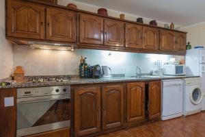 eine Küche mit Holzschränken und einem Herd mit Backofen in der Unterkunft Casa do Outeiro in Mondim de Basto