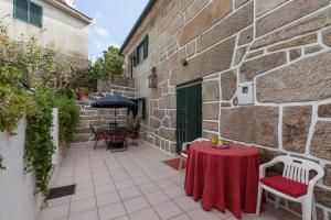 un patio con tavolo e sedie rossi e un edificio di Casa do Outeiro a Mondim de Basto