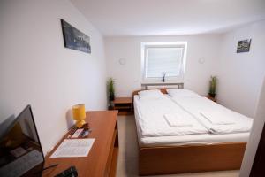 a small bedroom with a bed and a desk at MagnolijaHouse in Brežice