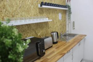 a kitchen counter with a microwave and a sink at The Central Guesthouse in Faro