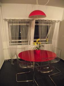 una mesa de comedor roja con sillas y una ventana en Corporal Apartment Budapest, en Budapest