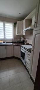 a kitchen with white cabinets and a stove top oven at maison nathalia in Jávea