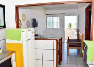 a kitchen with a white refrigerator and a table at Condominio Oliveira in Maragogi