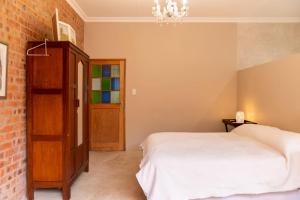 a bedroom with a bed and a brick wall at Jeffreys Guest Rooms in Jeffreys Bay