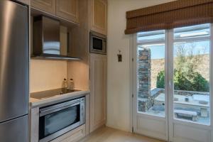 a kitchen with a sink and a refrigerator and a window at Pasithea Villa Kea in Vourkari