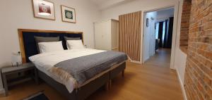 a bedroom with a large bed and a brick wall at Apartamenty SIENKIEWICZA 8 in Żywiec