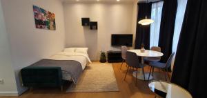 a bedroom with a bed and a table and a dining room at Apartamenty SIENKIEWICZA 8 in Żywiec