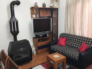 a living room with a couch and a stove at Apartament KiÇi Korce in Korçë