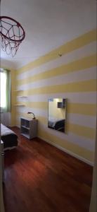 una camera da letto con pareti a righe gialle e bianche e uno specchio di Cittadella22 a Firenze